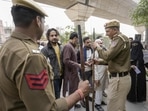Police personnel stand guard as voters wait to cast their votes for the Municipal Corporation of Delhi (MCD) elections, at a polling station in Jafrabad in north-east Delhi on Sunday. (PTI) Police personnel stand guard as voters wait to cast their votes for the Municipal Corporation of Delhi (MCD) elections, at a polling station in Jafrabad in north-east Delhi on Sunday. (PTI)