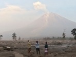 Villagers stand on an area covered in volcanic ash as Mount Semeru looms in the background in Kajar Kuning village in Lumajang, East Java, Indonesia, Monday, December 5, 2022. (AP Photo/Imanuel Yoga) Villagers stand on an area covered in volcanic ash as Mount Semeru looms in the background in Kajar Kuning village in Lumajang, East Java, Indonesia, Monday, December 5, 2022. (AP Photo/Imanuel Yoga)