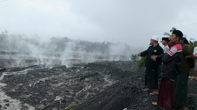 Indonesia's Semeru Volcano: Villagers watch hot smoke from the ground at the Curah Kobokan village following Mount Semeru's volcanic eruption. (AFP) Indonesia's Semeru Volcano: Villagers watch hot smoke from the ground at the Curah Kobokan village following Mount Semeru's volcanic eruption. (AFP)