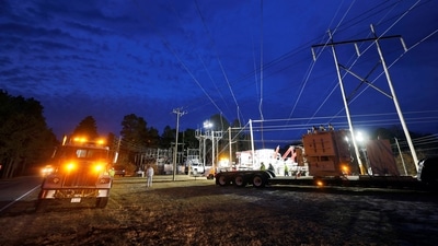 Duke Energy personnel work to restore power at a crippled electrical substation that the workers said was hit by gunfire after the Moore County Sheriff said that vandalism caused a mass power outage, in Carthage, North Carolina, U.S. December 4, 2022. (Reuters)
