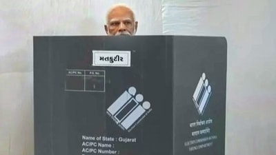 PM Modi arrived at the polling station at Nishan High School in Ranip locality of Ahmedabad at around 9.30 am and stood in a queue for a while to cast his vote. (PTI)
