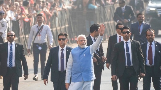 Prime Minister Narendra Modi waves to people as he arrives to cast his vote during the second phase of Gujarat state assembly elections in Ahmedabad, Monday.(AP)