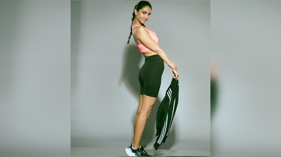 Vaani Kapoor wore a pink sports bra which she teamed with black biker shorts and sneakers. Holding her jacket in her hand, she posed for the camera.(Instagram/@_vaanikapoor_)