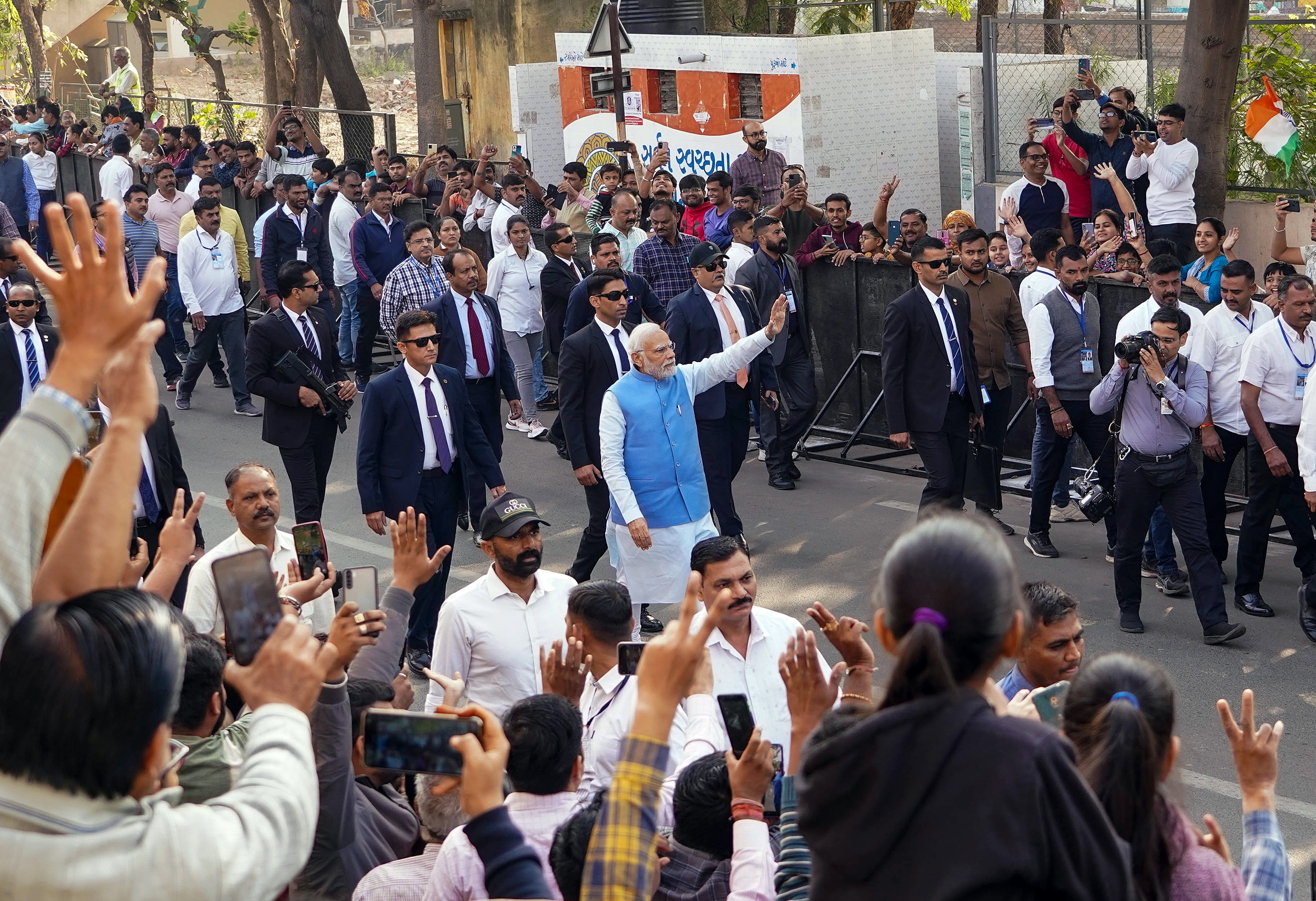 Prime Minister Narendra Modi waves to supporters on his way to the polling booth to cast his vote for the second phase of Gujarat assembly elections, in Ahmedabad on Monday. (ANI Photo) Prime Minister Narendra Modi waves to supporters on his way to the polling booth to cast his vote for the second phase of Gujarat assembly elections, in Ahmedabad on Monday. (ANI Photo)