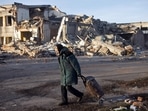 An elderly woman pulls a trolley bag past a destroyed building in Bakhmut, Donetsk region, on December 4, amid Russia's invasion of Ukraine. According to the Donetsk region military administration, Bakhmut, besieged by Russian forces for months, has witnessed some of the most ferocious fighting of the war.(Yevhen Titov / AFP)