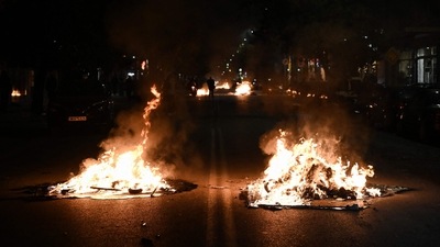 This photograph taken on December 5, 2022, shows burning roadblocks placed by members of the Roma community in Greece outside of the hospital where a Roma teenager is receiving treatment after being shot by police, in Thessaloniki. (AFP) This photograph taken on December 5, 2022, shows burning roadblocks placed by members of the Roma community in Greece outside of the hospital where a Roma teenager is receiving treatment after being shot by police, in Thessaloniki. (AFP)