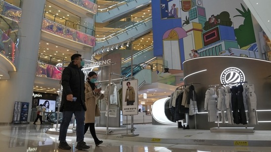 Shoppers walk through a shopping mall after it reopened following the easing of anti-virus controls in Beijing, on December 6. The easing of coronavirus restrictions has sparked optimism among investors for a broader reopening of the world's second biggest economy that could boost global growth. (Andy Wong / AP)