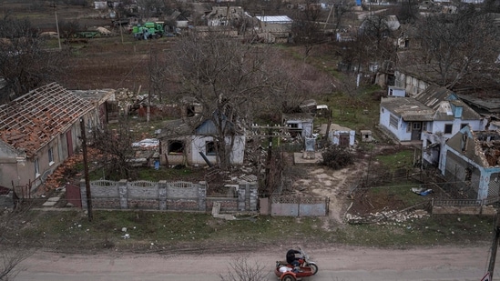 Russia-Ukraine War: A man rides a motorbike in front of houses which have been destroyed.(AP) Russia-Ukraine War: A man rides a motorbike in front of houses which have been destroyed.(AP)