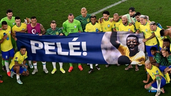 Brazil's players hold a banner dedicated to banner Brazilian football legend Pele at the end of the Qatar 2022 World Cup round of 16 football match between Brazil and South Korea