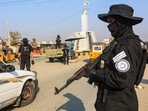 A member of the Taliban security forces stand guard at a checkpoint along a street in Jalalabad. 