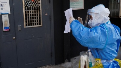 Covid In China: A health worker in protective suit checks the address of a resident to administer a Covid test. (Reuters)