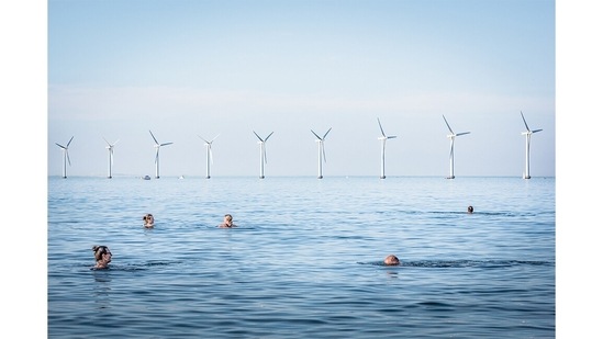 Winner: Adapting for Tomorrow | New Ways To The Future (III): Copenhagen, Denmark (13/07/2021) – A view of the Middelgrunden offshore windfarm from Amager Strand, a very popular beach in Copenhagen, Denmark, on July 13, 2021. The wind farm landscape perfectly integrates with this very popular beach where local people go to sunbathe or play water sports. The wind farm was developed with a strong involvement of the local community. Just over 14 % of the Danish electricity consumption is provided by wind. More than 150,000 Danish families are members of wind turbine cooperatives such as this one. (Simone Tramonte / Environmental photographer of the year)