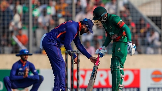 India's Virat Kohli, assists in fixing the grip of the bat of Bangladesh's Mehidy Hasan Miraz 