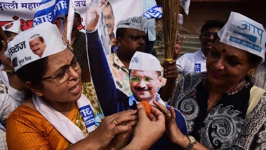 AAP supporters offering sweets (laddu) to party supremo and Delhi CM Arvind Kejriwal cut-out after crossing majority mark.&nbsp;(Bachchan Kumar / HT )