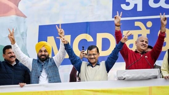 Delhi CM Arvind Kejriwal along with Punjab chief minister Bhagwant Mann and deputy CM Manish Sisodia showing victory sign after MCD win.(Sanchit Khanna/ HT)