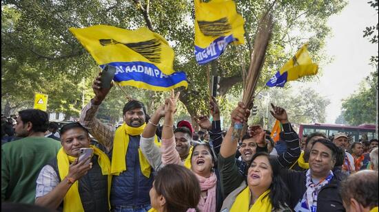 AAP supporters celebrate the party’s Delhi MCD election results outside a counting centre at Patel Nagar, in New Delhi, Wednesday. (PTI)
