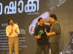 Mammootty gifts Asif Ai a Rolex watch at Rohrscach success meet as Dulquer Salmaan looks on.