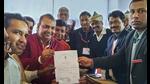 BJP candidate Akash Saxena (in red) receives the ‘Certificate of Election’ after winning the Rampur Assembly by-elections, in Rampur, Thursday. (PTI Photo) BJP candidate Akash Saxena (in red) receives the ‘Certificate of Election’ after winning the Rampur Assembly by-elections, in Rampur, Thursday. (PTI Photo)