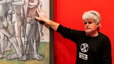 A climate activist with his hand glued to the perspex covering of Picasso's anti-war painting "Massacre in Korea" at the National Gallery of Victoria in Melbourne, Australia on October 9. Climate activists who have been targeting iconic artworks to demand an end to new gas and oil extraction projects have received mixed public reactions. (Matt Hrkac / Extinction Rebellion / AFP) A climate activist with his hand glued to the perspex covering of Picasso's anti-war painting "Massacre in Korea" at the National Gallery of Victoria in Melbourne, Australia on October 9. Climate activists who have been targeting iconic artworks to demand an end to new gas and oil extraction projects have received mixed public reactions. (Matt Hrkac / Extinction Rebellion / AFP)
