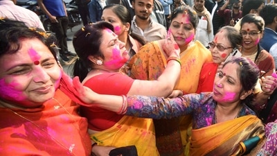 BJP supporters apply colors on each other's faces in celebration of the party's victory in Kurhani assembly constituency by-polls and Gujarat assembly elections in Patna. (ANI)