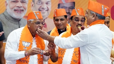 Incumbent Gujarat Chief Minister Bhupendra Patel and BJP state chief C R Paatil eat sweets as they take part in the celebration of party's victory in the state Assembly polls at the party headquarters in Gandhinagar. (ANI)