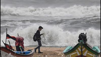 A man walks past fishing boats stationed along a beach amid gusty winds in Chennai on December 8, ahead of Cyclone Mandous’ forecasted landfall in north Tamil Nadu-south Andhra Pradesh coasts. (AFP) A man walks past fishing boats stationed along a beach amid gusty winds in Chennai on December 8, ahead of Cyclone Mandous’ forecasted landfall in north Tamil Nadu-south Andhra Pradesh coasts. (AFP)