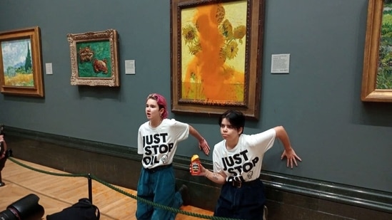 Activists of "Just Stop Oil" glue their hands to the wall after throwing soup at Vincent Van Gogh's painting "Sunflowers" at the National Gallery in London, Britain on October 14. The two women. 20 and 21, were arrested and charged with criminal damage for throwing soup at the painting but were later released on bail.(Just Stop Oil / REUTERS)
