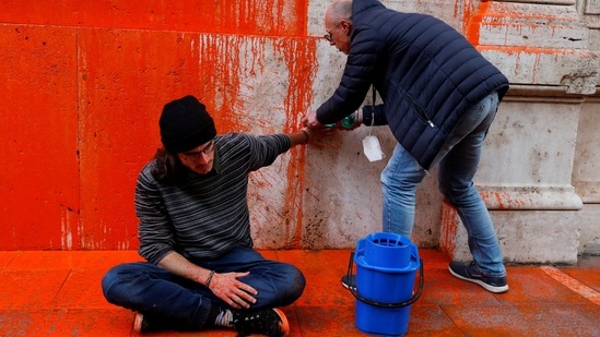 A person removes glue from the hand of a "Last Generation" activist during a protest outside state lender Cassa Depositi e Prestiti (CDP) building after activists of the group poured paint on the building in Rome, Italy, on November 16. In an unrepresentative poll by Deutsche Welle, Twitter followers were asked how they felt about acts of civil disobedience like the Monet mashed potato incident. Of the 491 people who answered, 22% said they raised awareness and helped. But 56% said such acts hurt the climate movement.(Remo Casilli / REUTERS)