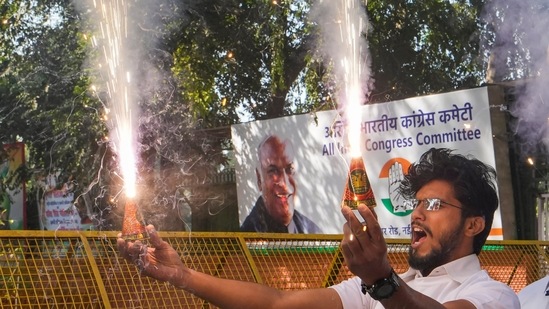A Congress worker burns firecrackers celebrating the party's win in Himachal Pradesh Assembly elections, at AICC headquarters in New Delhi.(PTI)