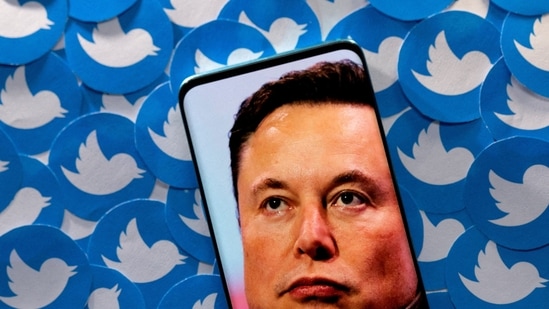 An image of Elon Musk is seen on a smartphone placed on printed Twitter logos in this picture illustration.(REUTERS)