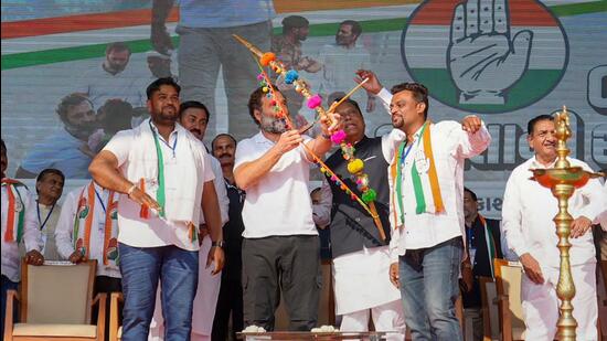 Congress leader Rahul Gandhi draws a bow and an arrow during a public rally in Surat, Gujarat. (PTI)