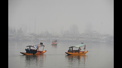 Boatmen row 'Shikaras' at the Dal Lake during a cold and foggy morning, in Srinagar on Friday. (PTI) Boatmen row 'Shikaras' at the Dal Lake during a cold and foggy morning, in Srinagar on Friday. (PTI)