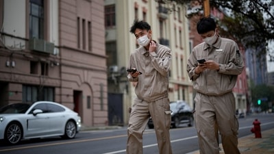 Covid In China: Two men wearing face masks walk on a street, as coronavirus disease (COVID-19) outbreaks continue in Shanghai, China. (Reuters)