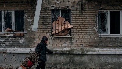 Russia-Ukraine War: A man carries brushwood for a wood stove to an apartment house basement used as a bomb shelter. (AP)
