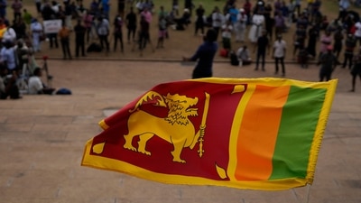 Sri Lanka Economic Crisis: A Sri Lankan flag is waved by a protester. (AP) Sri Lanka Economic Crisis: A Sri Lankan flag is waved by a protester. (AP)