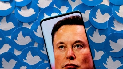 Elon Musk: An image of Elon Musk is seen on a smartphone placed on printed Twitter logos in this picture illustration. (Reuters)