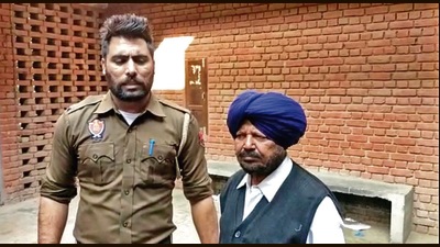 The accused (right) in custody of a vigilance official.