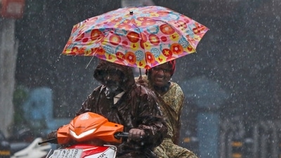 A scooterist drives amid gusty winds and heavy rain in Chennai, (AP)