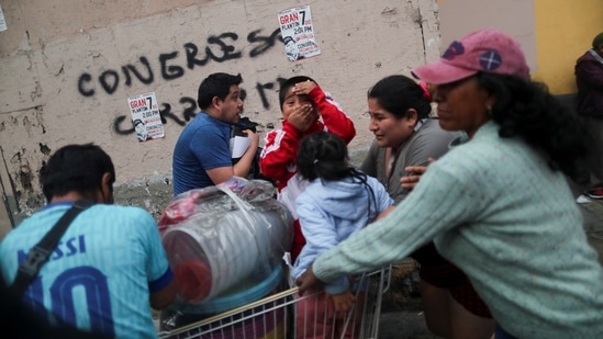 People affected by tear gas try to recover as massive crowds take to the streets in Lima, on December 8, in support of former President Pedro Castillo. Dozens voiced against his ouster by the Peruvian parliament, demanding presidential elections and the closure of Congress.&nbsp;(Sebastian Castaneda / REUTERS)