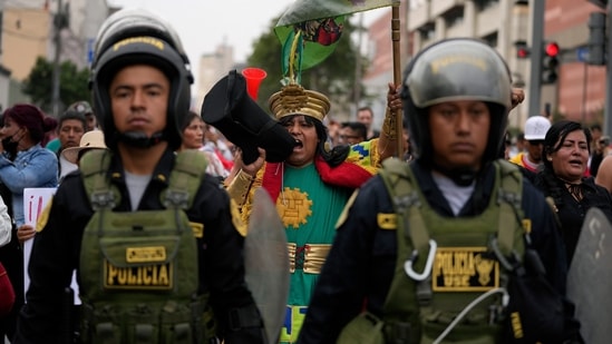 Police escort the Castillo's supporters in a march at the Plaza San Martin in Lima, Peru, on Thursday, December 8. Mexico's President Andres Manuel Lopez Obrador revealed that Castillo had requested asylum, which he was willing to grant, but the leftist was arrested before he could arrive at the country's embassy. Mexico was holding consultations with Peru's new government about giving asylum to Castillo, Foreign Minister Marcelo Ebrard later announced, AFP reported.(Fernando Vergara / AP)