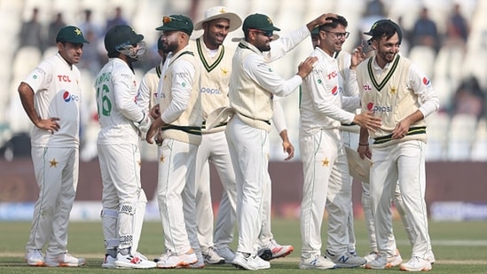 Babar Azam of Pakistan congratulates Abrar Ahmed of Pakistan (2nd from right) on the wicket of Joe Root