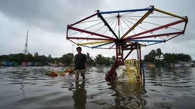 A man walks through a waterlogged area in Chennai caused by the downpour that followed the landfall. (PTI) A man walks through a waterlogged area in Chennai caused by the downpour that followed the landfall. (PTI)