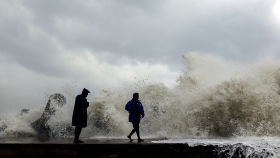 Cyclone Mandous: People stand on Kasimedu fishing harbour being hit by the high tides due to the strong winds triggered by Cyclone Mandous, in Chennai on Friday.(ANI)