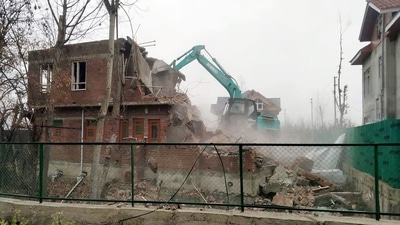 A house of the designated Jaish-e-Mohammed (JeM) terrorist Ashiq Nengroo, which is built on an encroached government land, is being demolished at the New Colony, Rajpora, in Pulwama on Saturday. (ANI Photo) A house of the designated Jaish-e-Mohammed (JeM) terrorist Ashiq Nengroo, which is built on an encroached government land, is being demolished at the New Colony, Rajpora, in Pulwama on Saturday. (ANI Photo)