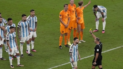 Referee Antonio Mateu shows a yellow card to Argentina's Lionel Messi during the World Cup quarterfinal soccer match between the Netherlands and Argentina, at the Lusail Stadium in Lusail, Qatar, Saturday, Dec. 10, 2022. (AP) Referee Antonio Mateu shows a yellow card to Argentina's Lionel Messi during the World Cup quarterfinal soccer match between the Netherlands and Argentina, at the Lusail Stadium in Lusail, Qatar, Saturday, Dec. 10, 2022. (AP)