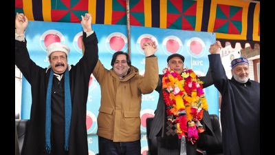 Jammu and Kashmir Peoples’ Conference president Sajad Lone join hands with party members as National Conference senior vice-president central zone from Khansahib constituency of Budgam Manzoor Ahmad Wani joins the party in Srinagar on Sunday. (ANI)