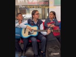 The image shows three students performing B Praak’s Mann Bharrya in Delhi metro.