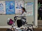Covid In Shanghai: A woman rides past a coronavirus testing facility.