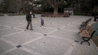 Beijing Air Pollution: A man wearing a face mask plays a ball with a child at an area used to be crowded with residents at a public park in Beijing. (AP) Beijing Air Pollution: A man wearing a face mask plays a ball with a child at an area used to be crowded with residents at a public park in Beijing. (AP)