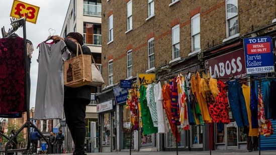 UK Economy: A customer looks at a clothing stall at Petticoat Lane Market in London, UK. (Bloomberg)
